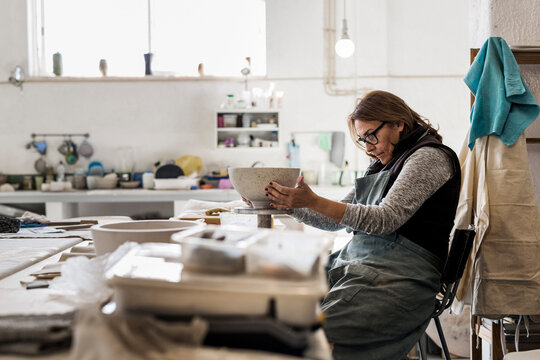 Woman making pottery in workshop