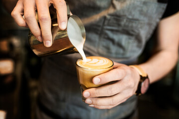 Mid section of barista preparing coffee