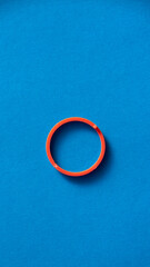 Anillo de plástico rojo sobre fondo azul