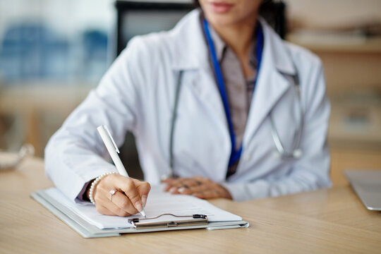 Cropped image of general practitioner filling form with personal data of patient