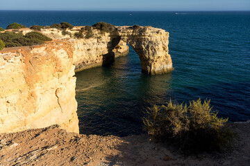 Fototapeta na wymiar Landscape of Albandeira beach, cliffs, and natural arch in the Algave region at sunset. Portugal.