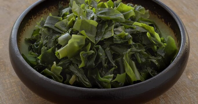 Wakame seaweed in a bowl. Asian cuisine food ingredient. Table spin.