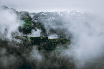 Moody foggy landscape in the mountains of Trolltunga,  Norway