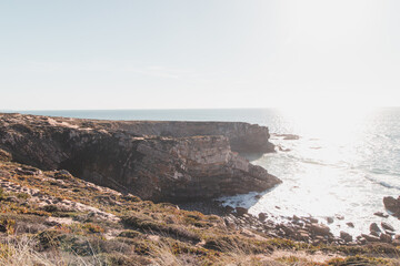 Breathtaking cliffs with a pebble beach in the afternoon sun on the Atlantic coast at Vila Nova de Milfontes, Odemira, Portugal. In the footsteps of Rota Vicentina. Fisherman trail
