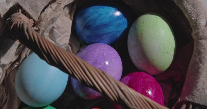 Painted Easter eggs rotate in a wicker basket in the sun