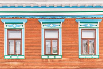 Windows with carved wooden architraves. Facade of typical merchant tatar house.