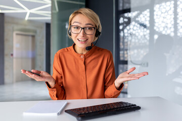 Web camera view, young beautiful female office worker talking remotely with colleagues clients,...