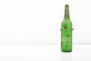 Abandoned Beverage Green Glass Bottle on White Background - Environmental Pollution Concept