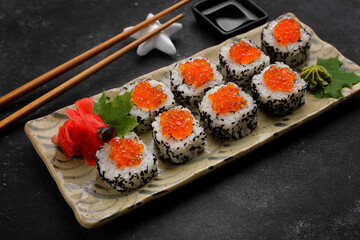 Exquisite sushi rolls with traditional accompaniments, with wasabi and ginger