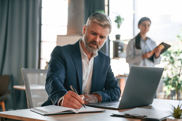 Senior man is with woman. Business people are working together in the office
