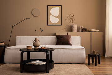 Interior design of cozy living room interior with mock up poster frame, modular sofa, round coffee table, vase with dried flowers, brown pillow, lamp and personal accessories. Home decor. Template.