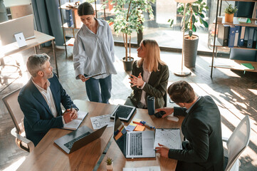By the table with laptops. Top view. Group of business people are working in the modern office
