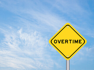 Yellow transportation sign with word overtime on blue color sky background