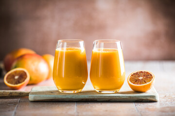 Two mango lassi or kesar milk in glasses. Indian healthy ayurvedic cold drink with mango. Freshness lassi made of yogurt, water, spices, fruits and ice.