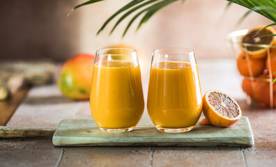 Two mango lassi or kesar milk in glasses. Indian healthy ayurvedic cold drink with mango. Freshness lassi made of yogurt, water, spices, fruits and ice.