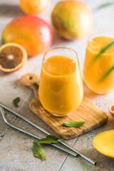 Two mango lassi or kesar milk in glasses. Indian healthy ayurvedic cold drink with mango. Freshness...