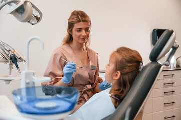 Obraz premium Female doctor is working with little girl. In the stomatological cabinet