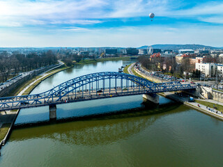 Krakow, Poland. Blue Pilsudski tied-arc bridge, observation and tourist balloon over Vistula River and far view of a Ferris wheel