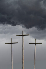 Three crosses with ominous dark clouds above