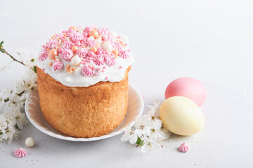 Traditional Easter sweet bread or cakes with white icing and sugar decor, colored eggs and cherry...