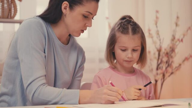 Smiling parent and little girl drawing together at home, happy childhood, diy