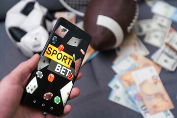 Sports betting website in a mobile phone screen, ball, money