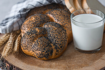 Classic wheat braid with poppy seeds. Delicious bread close-up. Freshly baked sourdough bread with a golden crust on a wooden board. The context of a bakery with delicious bread. 