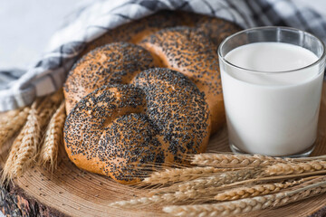 Classic wheat braid with poppy seeds. Delicious bread close-up. Freshly baked sourdough bread with a golden crust on a wooden board. The context of a bakery with delicious bread. 