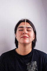 Eyebrow master making correction of eye brows with wax depilation in beauty salon