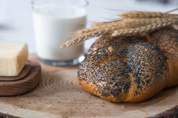 Classic wheat braid with poppy seeds. Delicious bread close-up. Freshly baked sourdough bread with a golden crust on a wooden board. The context of a bakery with delicious bread. 