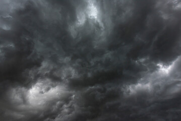 Obraz premium Dramatic dark storm rain clouds black sky background. Dark thunderstorm clouds rainny atmosphere. Meteorology danger windstorm disasters climate. Dark cloudscape storm disaster gloomy gray cloud sky