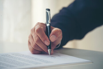 Asian business man using pen signing on new contract to starting projects in conference room. Close up manager businessman hands sign contract working meeting. Business agreement concepts.