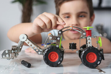 little preteen boy play with steel mechanical constructor set close up photo