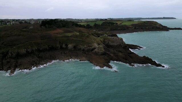 Rocky and jagged cliff near Plage du Verger beach at Cancale, France. Aerial sideways