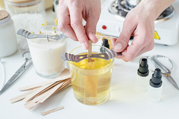 closeup of woman setting the wooden wick into handmade candle