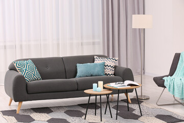 Comfortable sofa, armchair and coffee table in stylish living room. Interior design