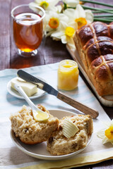 Cross buns served with butter, honey and tea. Easter breakfast.