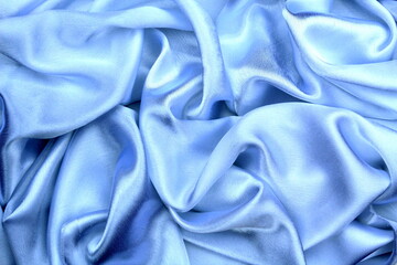 Obraz premium Satin beautiful blue silk fabric lies with drapery. 