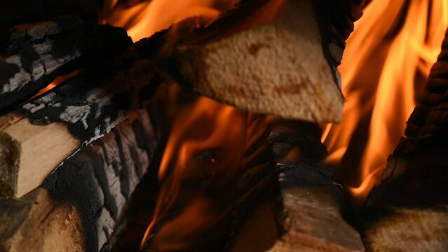 un'uomo prepara il fuoco nella stufa, la legna che arde in una casa di montagna