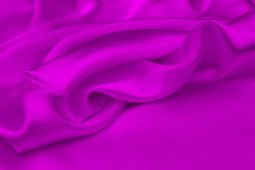 Obraz premium Satin beautiful silk fabric in lilac color lies with drapery. 
