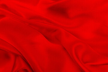 Fototapeta na wymiar The satin red fabric lays beautifully draped. 