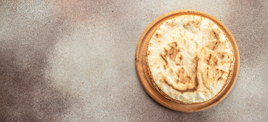 Pita bread on a wooden board. Traditional Arabic cuisine. Long banner format. top view