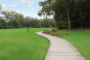 Beautiful public city park with pathway and green grass