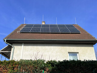 Home solar panel. Alternative energy is used for heating and water heating. Eco-friendly alternative energy for house. Residential family house suburban. Brown tile roof of home with solar panels. 