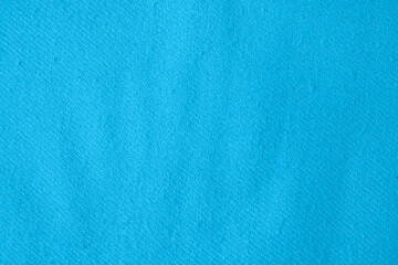 Light blue cloth with lint as background, top view. Before using fabric shaver