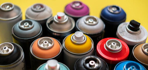 set of some spray paint cans of different colors flat lay