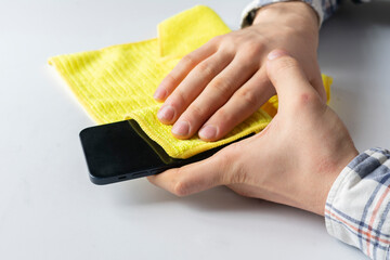 hand holding a microfiber napkin and wipe the dirty smartphone screen