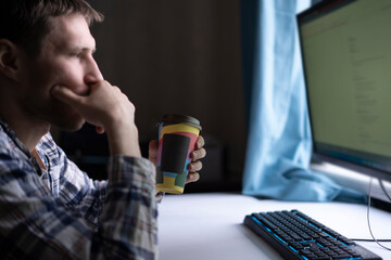 office worker holding a paper cup with hot dring while doing the task