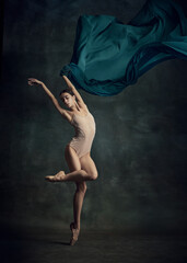 Charming ballerina posing with silk fabric over dark green background. Contemporary dance © Lustre Art Group 