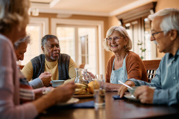 Fototapeta Happy senior woman talks to her friends during lunch in residential care home. obraz